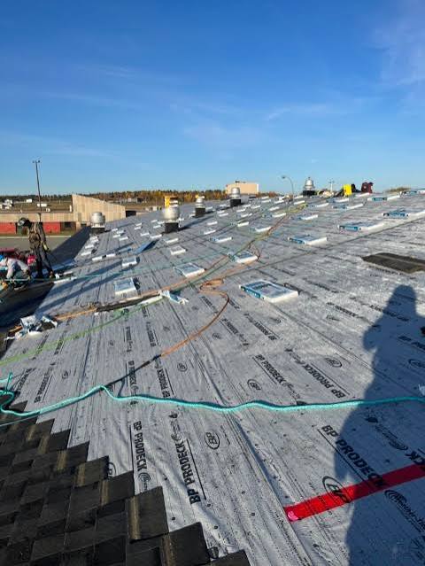 Roof installation showing underlayment before shingle completion