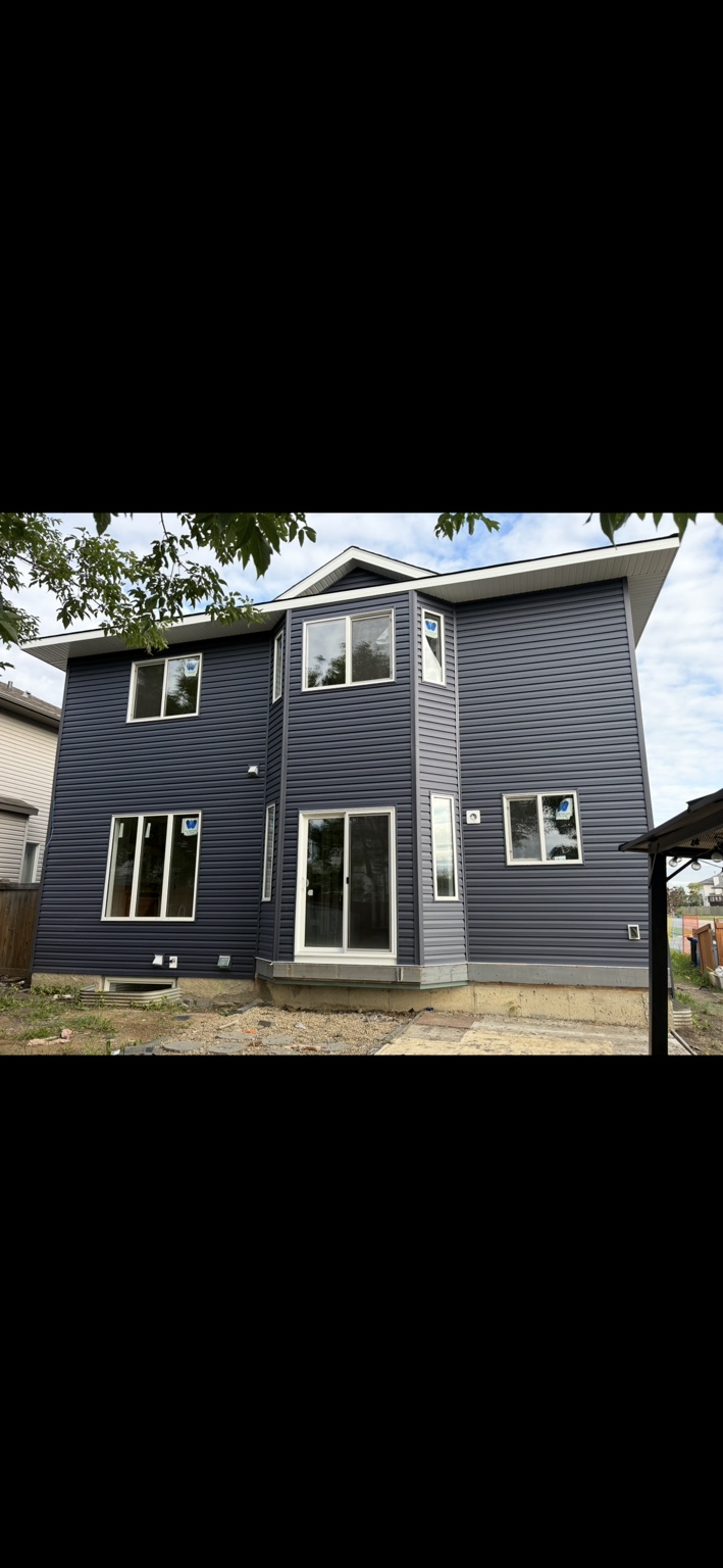 Blue siding and window trim across a two-storey rear elevation