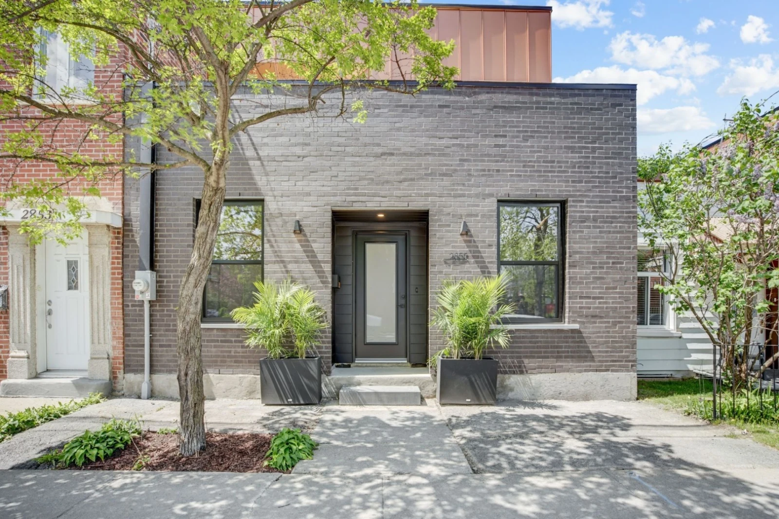 Completed dark glazed entrance door on a brick house