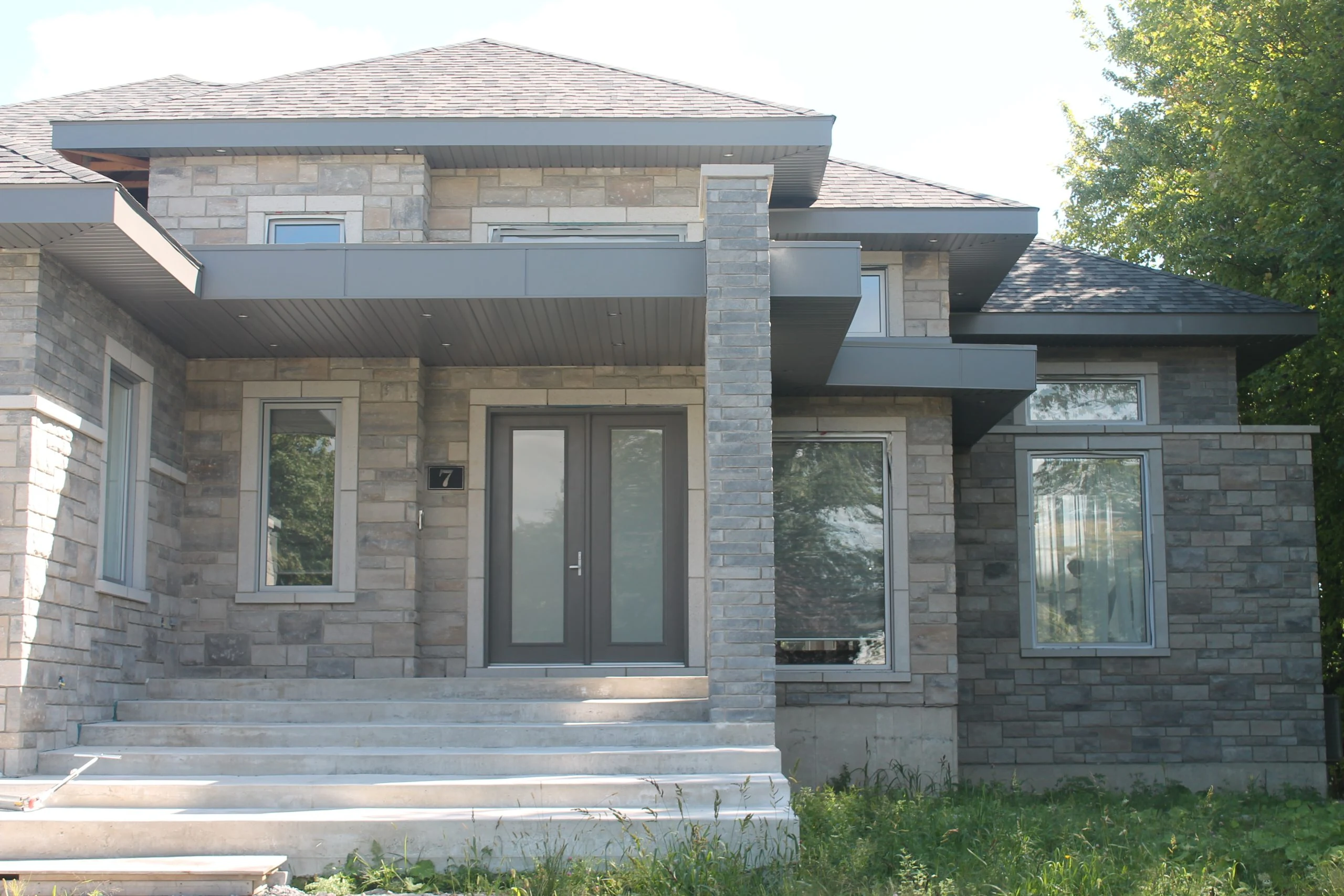 Installed double entrance doors on a stone-clad residence