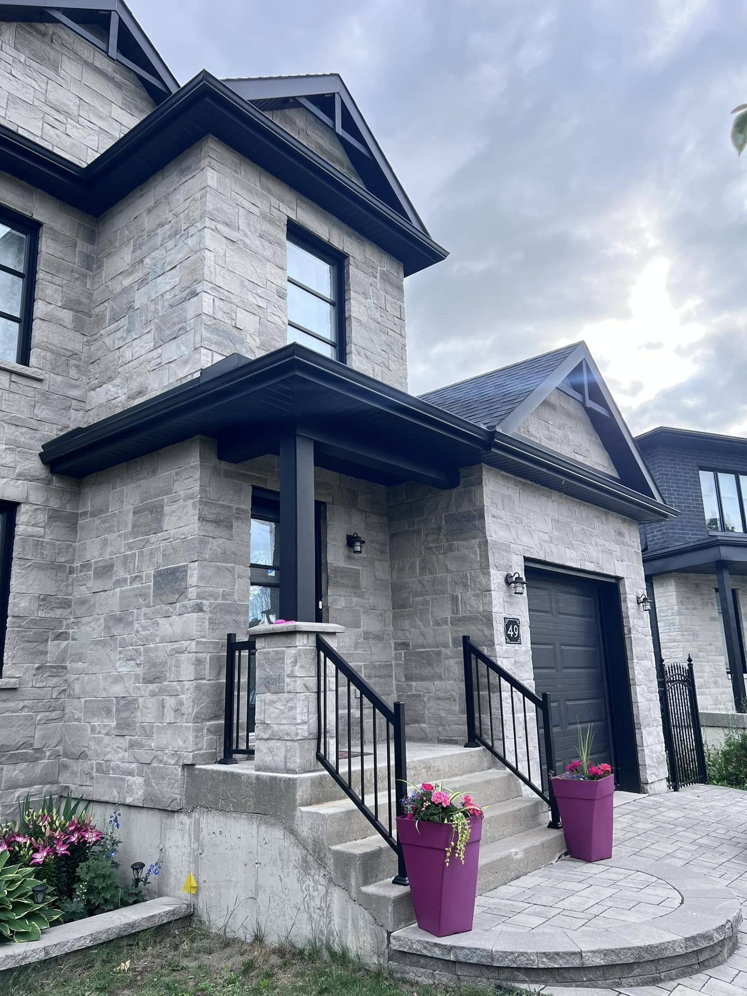 Finished dark soffit returns and fascia on a stone house entrance