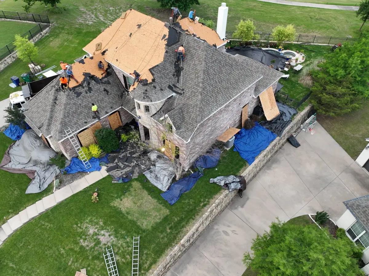 Aerial view of a crew removing roof shingles